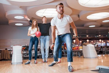 It must be strike. Young cheerful friends have fun in bowling club at their weekends.の写真素材