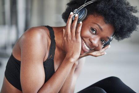 Taking a break. Portrait of african american girl in fitness clothes having a break after workout.の写真素材