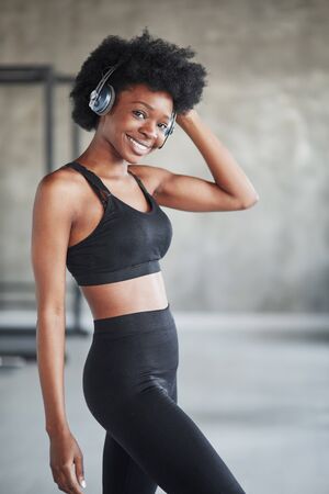 Alone in the room. Portrait of african american girl in fitness clothes having a break after workout.の写真素材