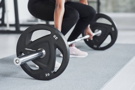 Lifting weights. Particle view of sportive girl in the gym at her weekends.の写真素材