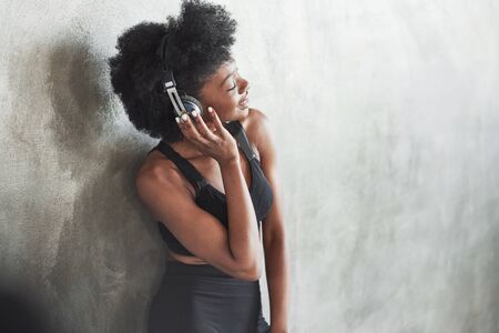 Cheerful mood. Portrait of african american girl in fitness clothes having a break after workout.の写真素材
