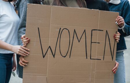Holding big poster. Group of feminist women have protest for their rights outdoors.の写真素材
