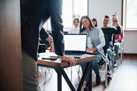 Man have a question. Hand raised up. Group of people at business conference in modern classroom at daytime.の写真素材