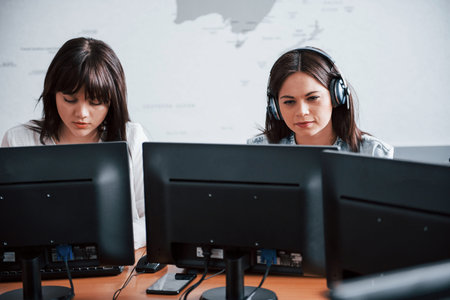 Photo of two employees. Young people working in the call center. New deals is coming.