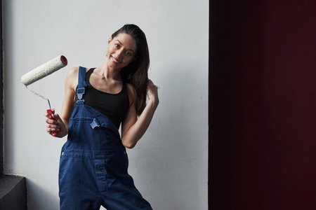 Happy woman. Young housewife decided to glue wallpaper in her new house in the room.の写真素材