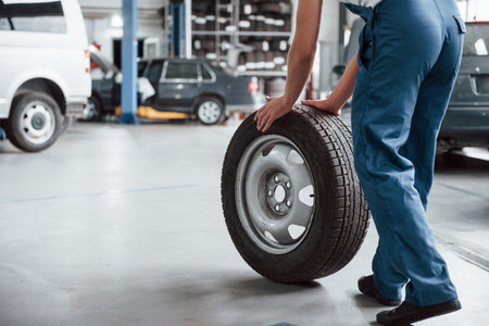 View from behind. Employee in the blue colored uniform works in the automobile salon.の写真素材
