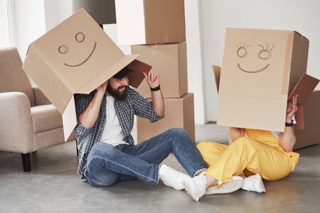 Playing with boxes. Happy couple together in their new house. Conception of moving.の写真素材
