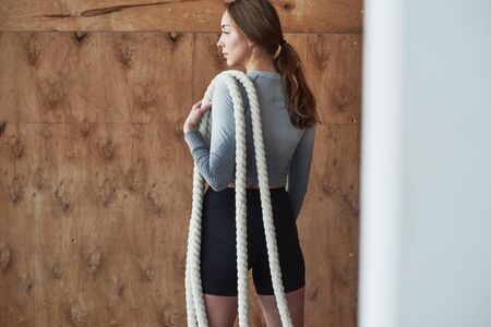 Rear view. Sportive young woman have fitness day in the gym at morning time.の写真素材