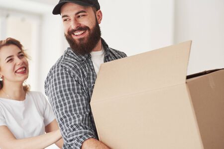 Sincere smiles. Happy couple together in their new house. Conception of moving.の写真素材
