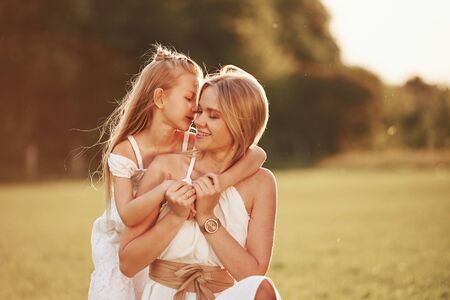 Closeness of people. Mother and daughter enjoying weekend together by walking outdoors in the field. Beautiful nature.の写真素材