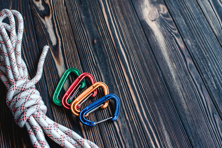 No one. Isolated photo of climbing equipment. Part of carabiner lying on the wooden table.