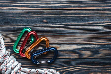 Bright and beautiful. Isolated photo of climbing equipment. Part of carabiner lying on the wooden table.の写真素材