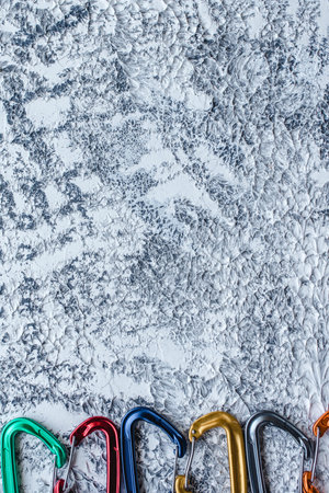 Modern art. Isolated photo of climbing equipment. Part of carabiner lying on the white and grey...