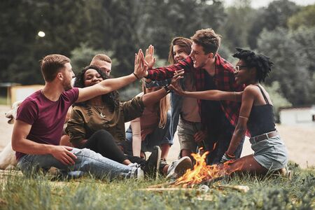 Together we will achieve success. Group of people have picnic on the beach. Friends have fun at weekend time.の写真素材