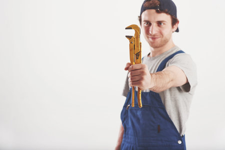 Irreplaceable thing. Man in blue uniform stands against white background in the studio.