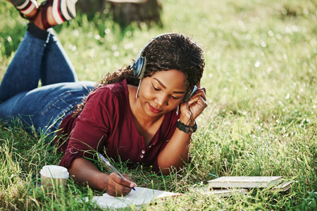 In the park at summertime. Cheerful african american woman.の写真素材