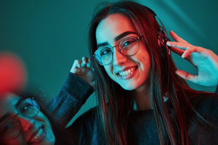 Cheerful mood. Studio shot indoors with neon light. Portrait of beautiful young girl.