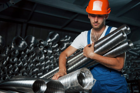 Final product. Man in uniform works on the production. Industrial modern technology.