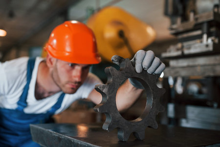Searching for defects. Man in uniform works on the production. Industrial modern technology.