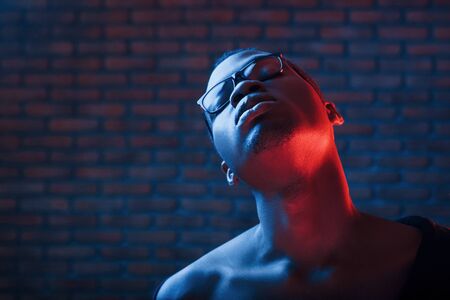 Futuristic neon lighting. Young african american man in the studio.の写真素材