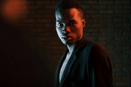 Beautiful reflection. Futuristic neon lighting. Young african american man in the studio.の写真素材