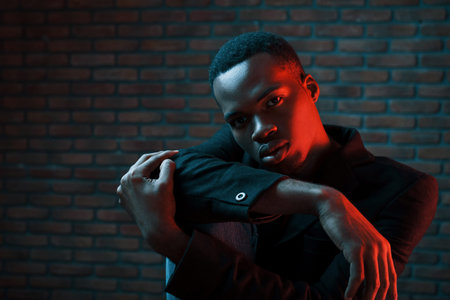 Futuristic neon lighting. Young african american man in the studio.