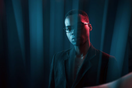 Interesting beams. Futuristic neon lighting. Young african american man in the studio.
