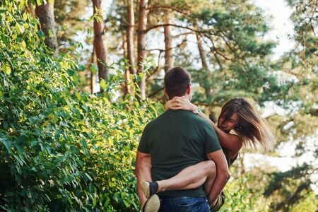 Near white colored car. Beautiful young couple have a good time in the forest at daytime.の写真素材