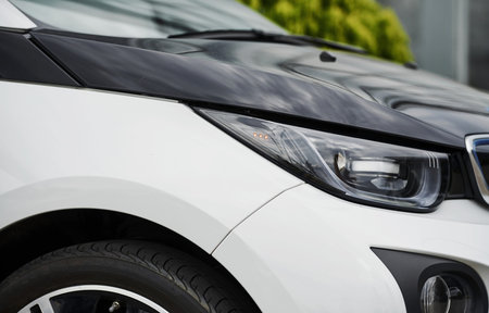 Particle view of brand new modern electric car. Cropped photo.
