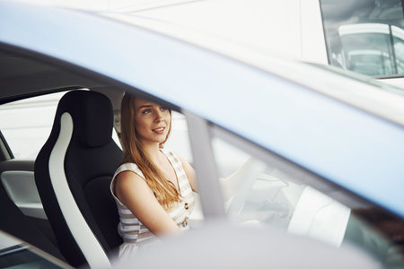 Female driver inside of modern automobile. Testing brand new car.