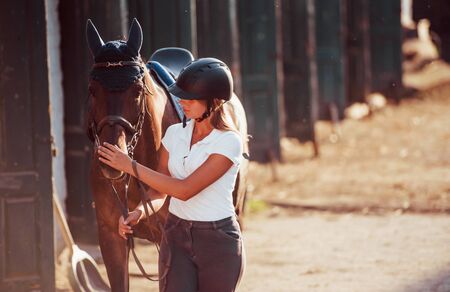 Horsewoman in uniform and black protective helmet with her horse.の写真素材