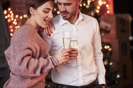 Passion in in the air. Nice couple celebrating new year in the new year decorated room.の写真素材