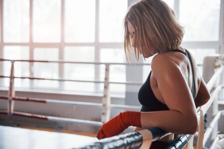 Waiting for the opponent. Tired after workout. Having rest in the gym for box sport training.の写真素材