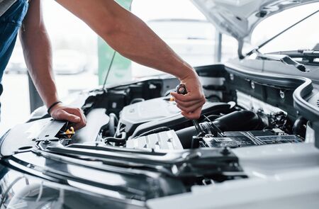 Here we go. Process of repairing car after accident. Man working with engine under the hood.の写真素材