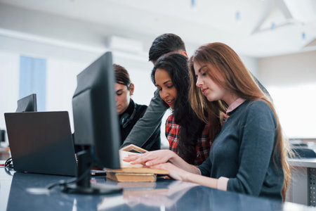 Side view. Group of young people in casual clothes working in the modern office.