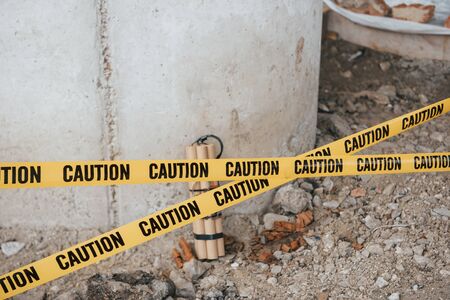 There could be catastrophic consequences. Dangerous explosive lying on the ground. Yellow caution tape in front.の写真素材