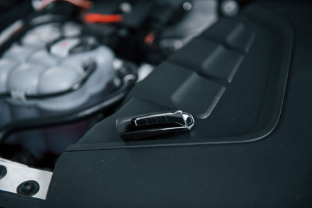 Repairing is done. Black keys leaning under the hood of automobile.の写真素材