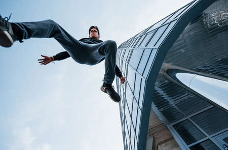 Young man doing parkour in the city at daytime. Conception of extreme sports.の写真素材