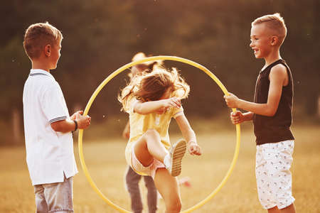 Jumping through the circle fitness tool. Kids having fun in the field.の写真素材