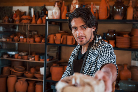 Handsome ceramist gives his fresh product that is in the paper to the customer.