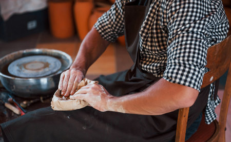 Close up photo of ceramist packages his fresh product in the paper.