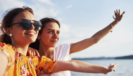 Selfie of two smiling girls outdoors that have a good weekend together at sunny day.