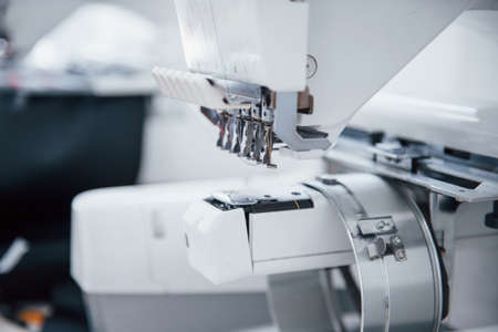 Close up view of white automatic sewing machine at factory.の写真素材