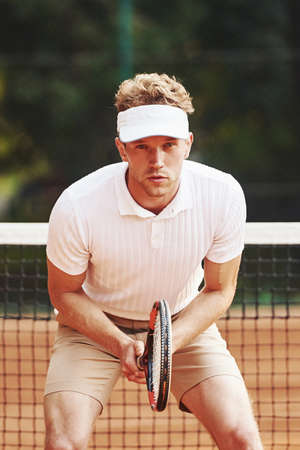 Young tennis player in sportive clothes is on the court outdoors.の写真素材