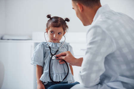 Young pediatrician works with little female visitor in the clinic.の写真素材