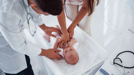 Young pediatrician is with little baby in the clinic at daytime.の写真素材