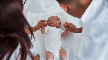 Young pediatrician is with little baby in the clinic at daytime.の写真素材
