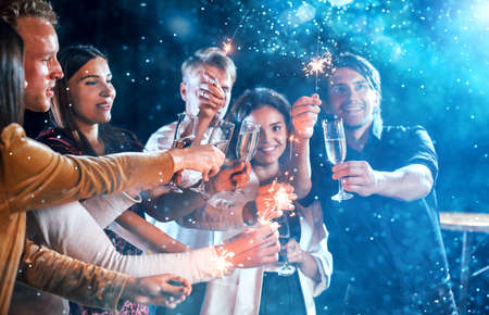 Group of cheerful young people have party and celebrating new year indoors.の写真素材