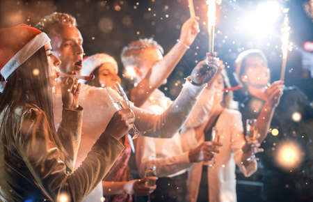 Group of cheerful young people have party and celebrating new year indoors.の写真素材