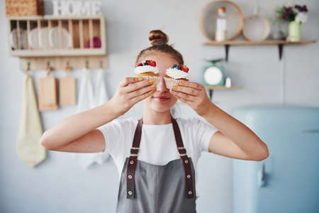 Woman stands indoors in the kitchen with homemade pie.の写真素材